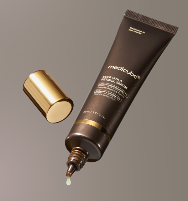 MEDICUBE Deep Vita A Retinol Serum 30ml with its gold cap removed, showing the narrow nozzle and a serum drop