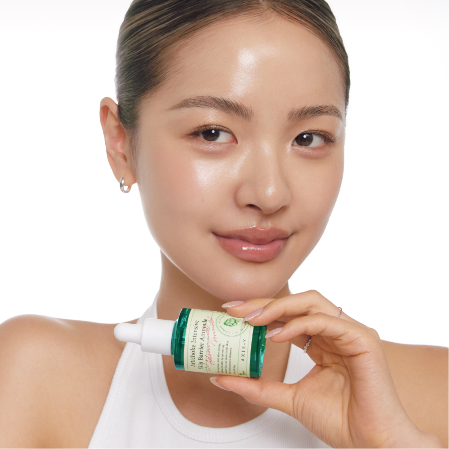 Modelo sosteniendo AXIS-Y Artichoke Intensive Skin Barrier Ampoule 30ml para mostrar el tamaño del frasco