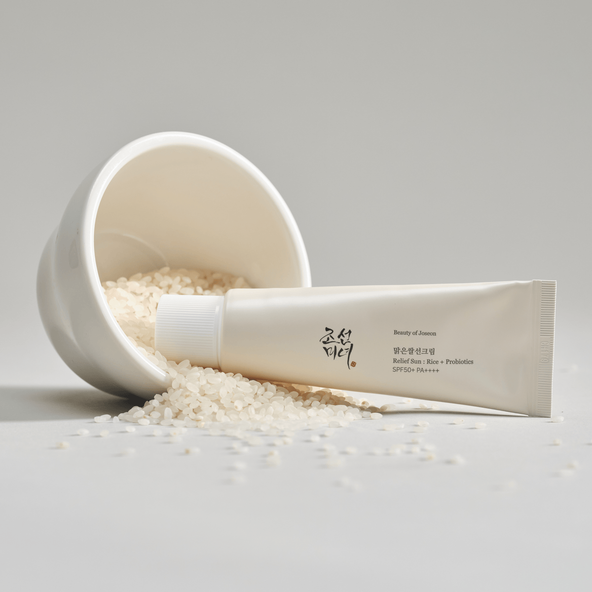 Beauty of Joseon Relief Sun Rice + Probiotics SPF50+ PA++++ tube beside a white bowl of rice.