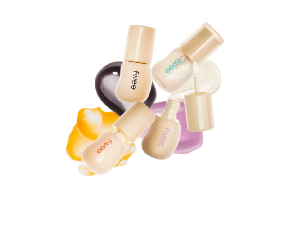 Four FWEE 3D Changing Gloss bottles with cream-colored caps and colored gloss swatches