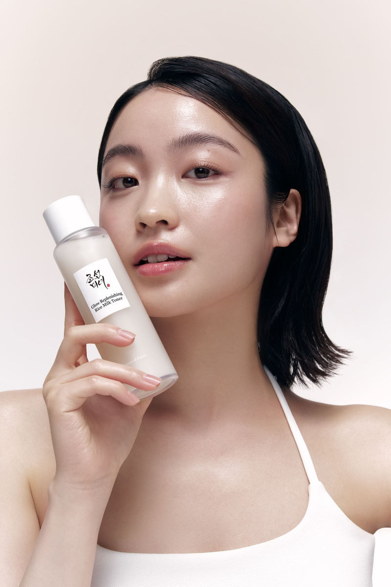 Modelo sosteniendo Beauty of Joseon Glow Replenishing Rice Milk Toner de 150 ml junto al rostro para mostrar el tamaño del frasco