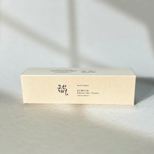 Caja de color crema de Beauty of Joseon Relief Sun colocada horizontalmente sobre una superficie clara